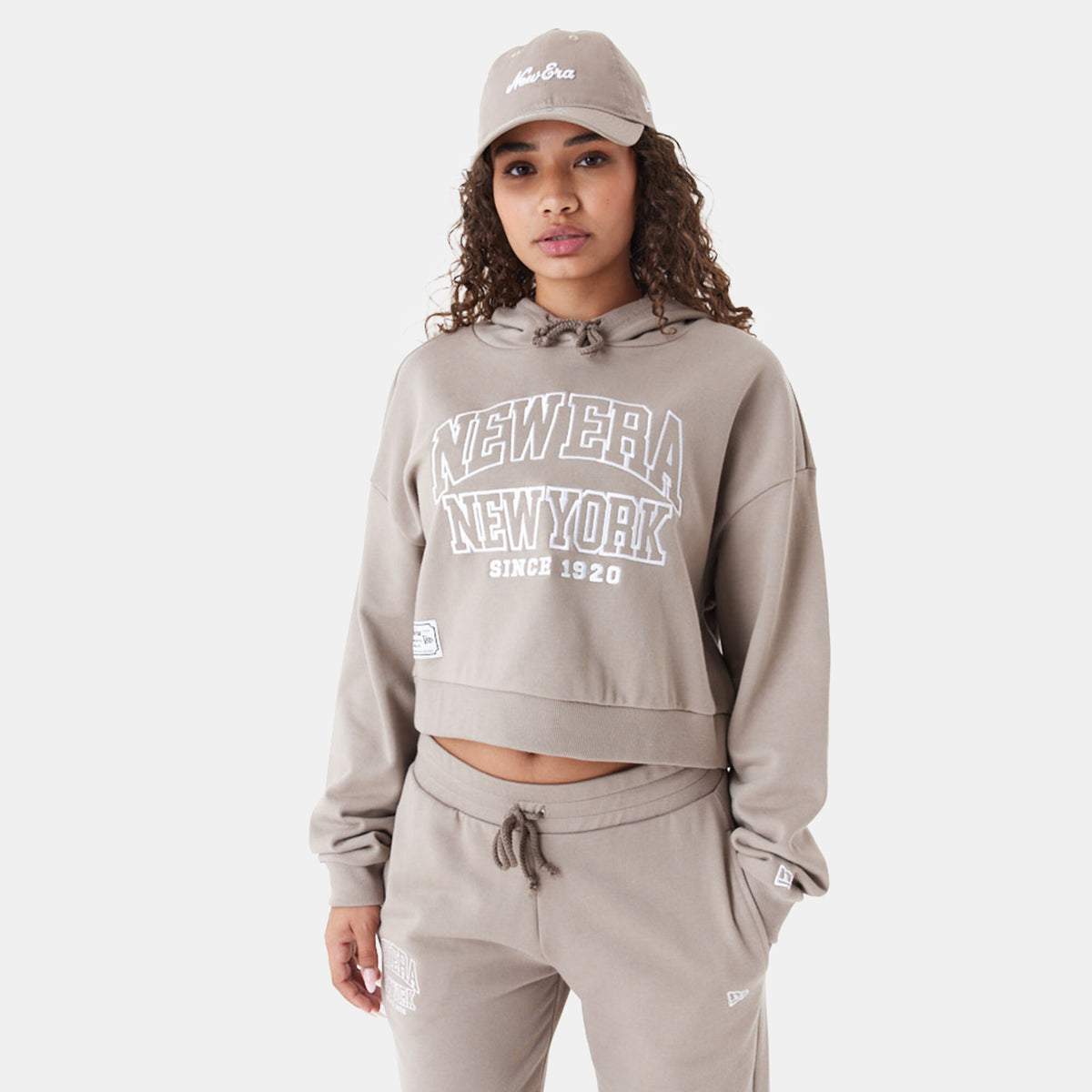 New Era women's Arch Wordmark cropped hoodie in beige, front view